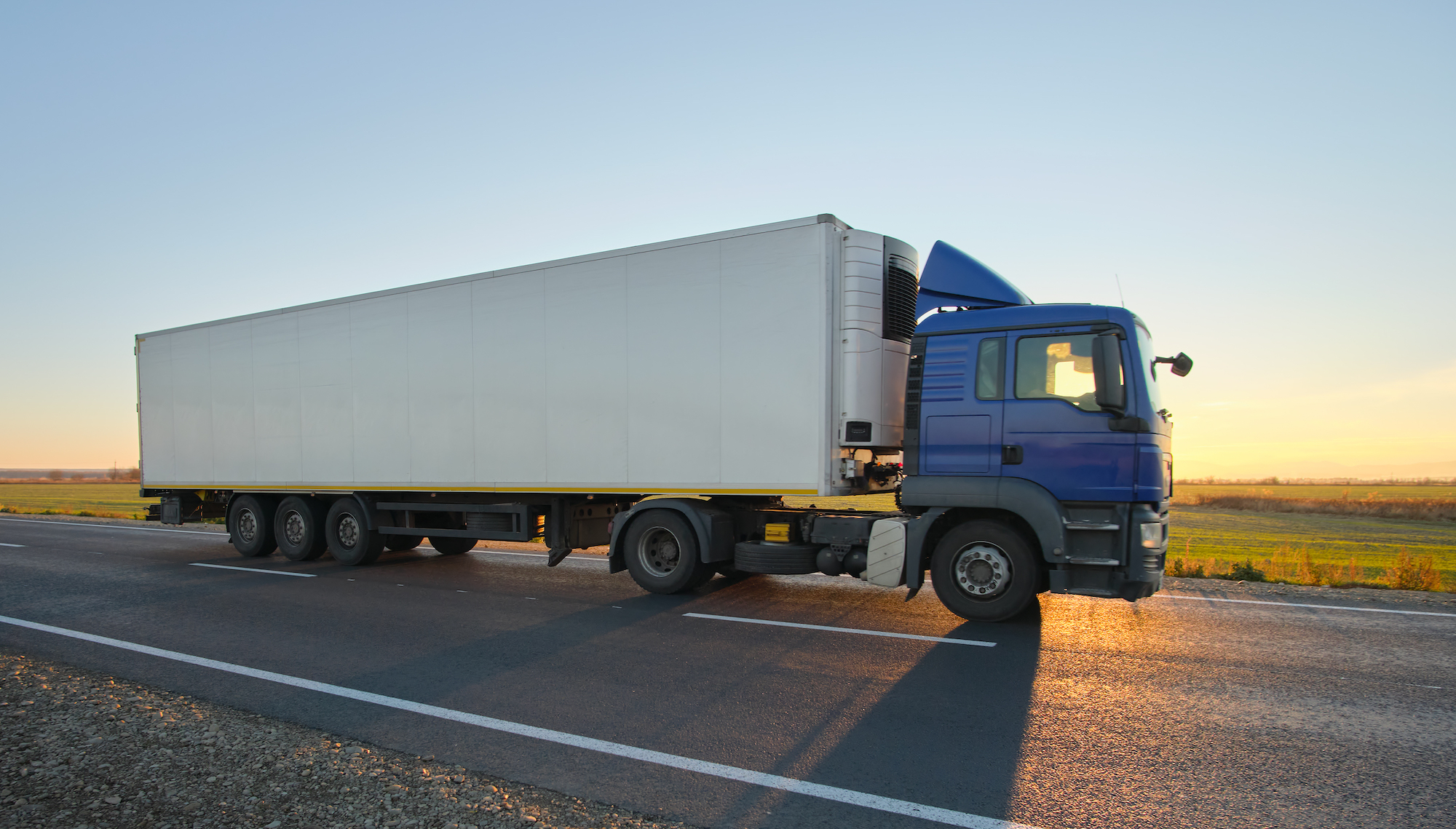 Semi Truck With Cargo Trailer Driving On Highway Hauling Goods In Evening. Delivery Transportation And Logistics Concept